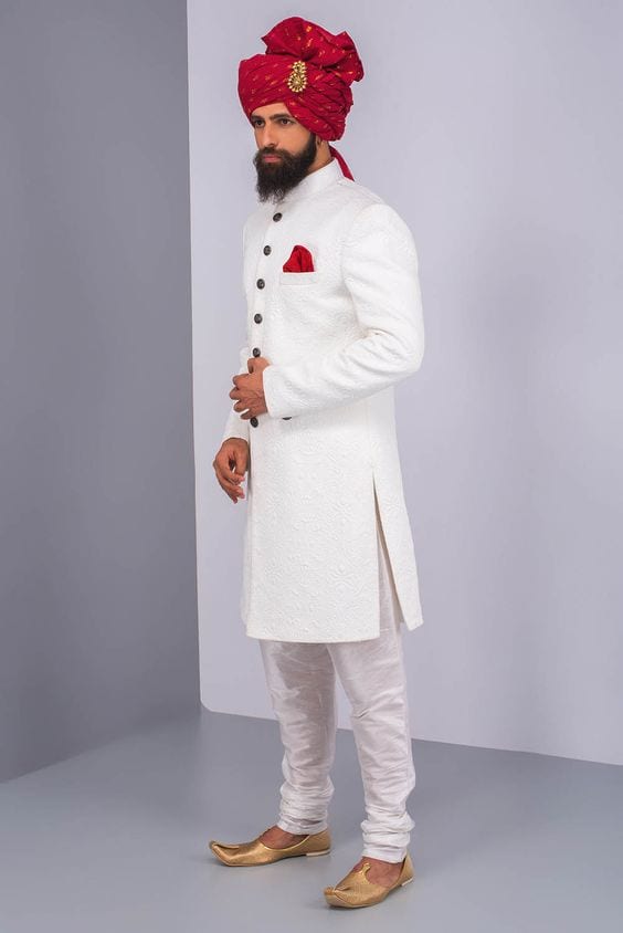 simple white sherwani and pajama with golden mojari for groom