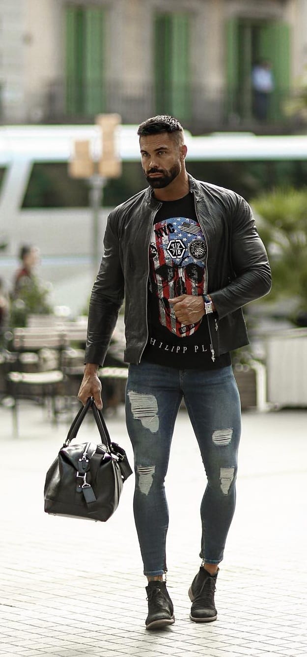 Black t-shirt, black leather jacket and blue distressed denims and a bag