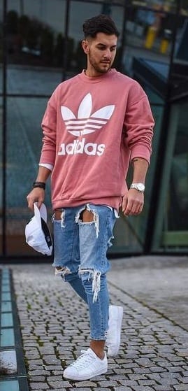 casual-outfit-Sweatshirt-with-ripped-ligh-tblue-denims-styled-with-white-sneakers-and-cap