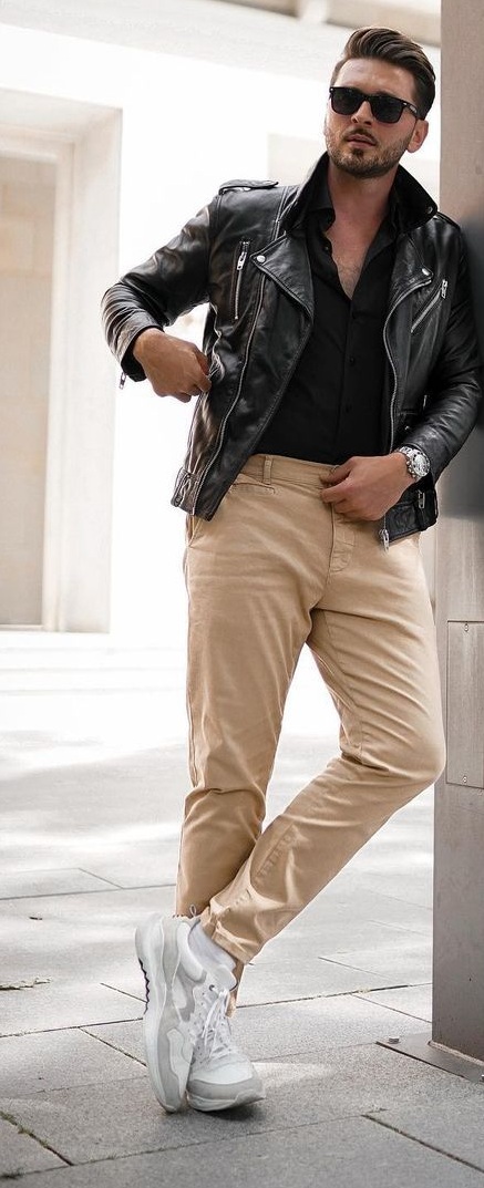 a man wearing khaki pants and a green shirt and holding a bag Stock Photo  by Icons8