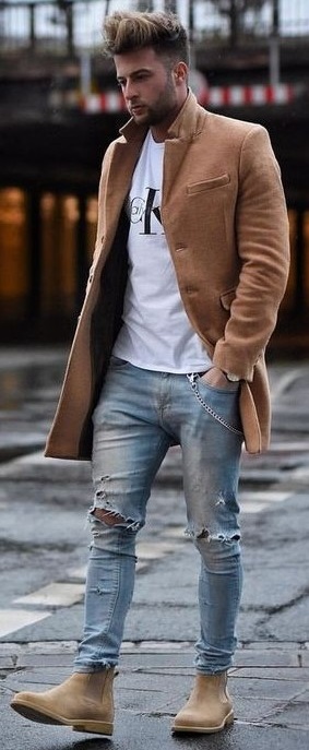 White t-shirt with ripped denims and light brown long overcoat and brown boots_