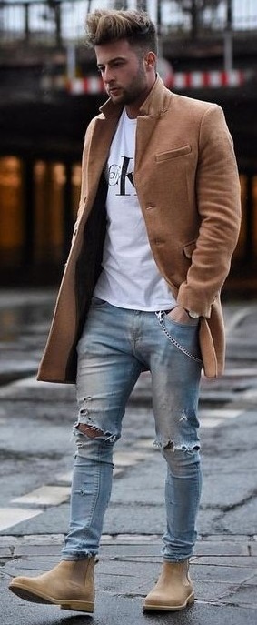 White t-shirt with ripped denims and light brown long overcoat and brown boots_