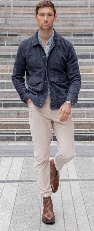 beige chinos with dark blue buttoned jacket and light blue shirt, wearing a wrist watch in hands_