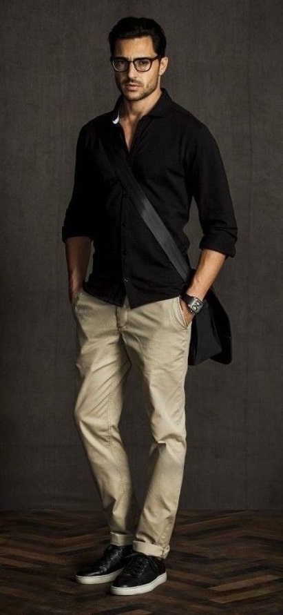 black shirt with cream chinos accessorized with a watch and a bag and black shoes_