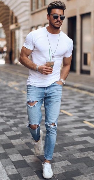 ripped denims with white t-shirt, accessorized with locket, bracelet, shades and a watch wearing white sneakers_