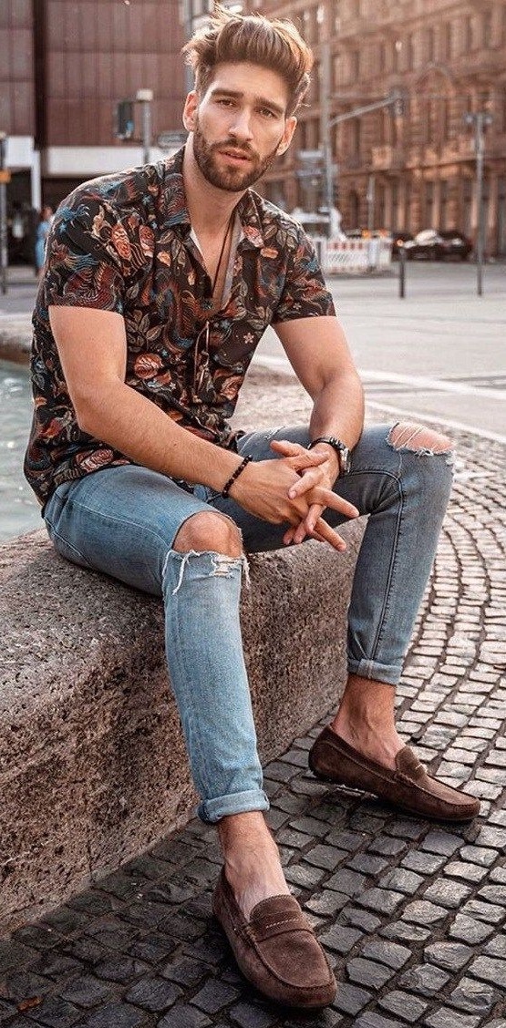 Floral shirt with ripped denims and waist accessories wearing suedes