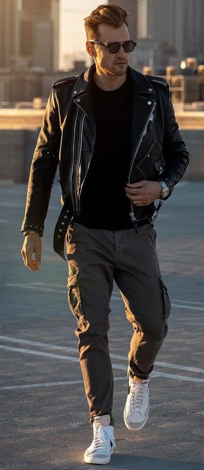 biker jacket with black tshirt and olive green joggers with white sneakers accessorized with shades and a watch for smart casual look