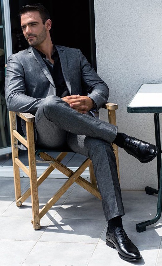 shiny grey suit with blak under shirt and boots