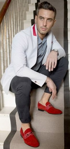 Moccasins of red leather shoes with black chino and a coat with greenish undershirt accessorized by a watch
