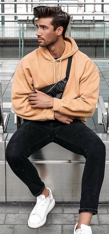 oversized hoodie in orange color with black denims and white sneakers