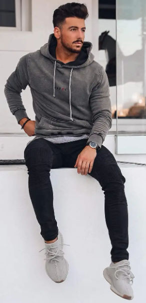 pullover grey hoodies with drawstring and a black denim which is been accessorized with a watch, bracelet and a grey sneakers