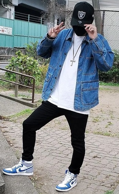 denim jacket with white tshirt and black bottoms, accessorized with the sneaker brand Nike, a cross and a cap