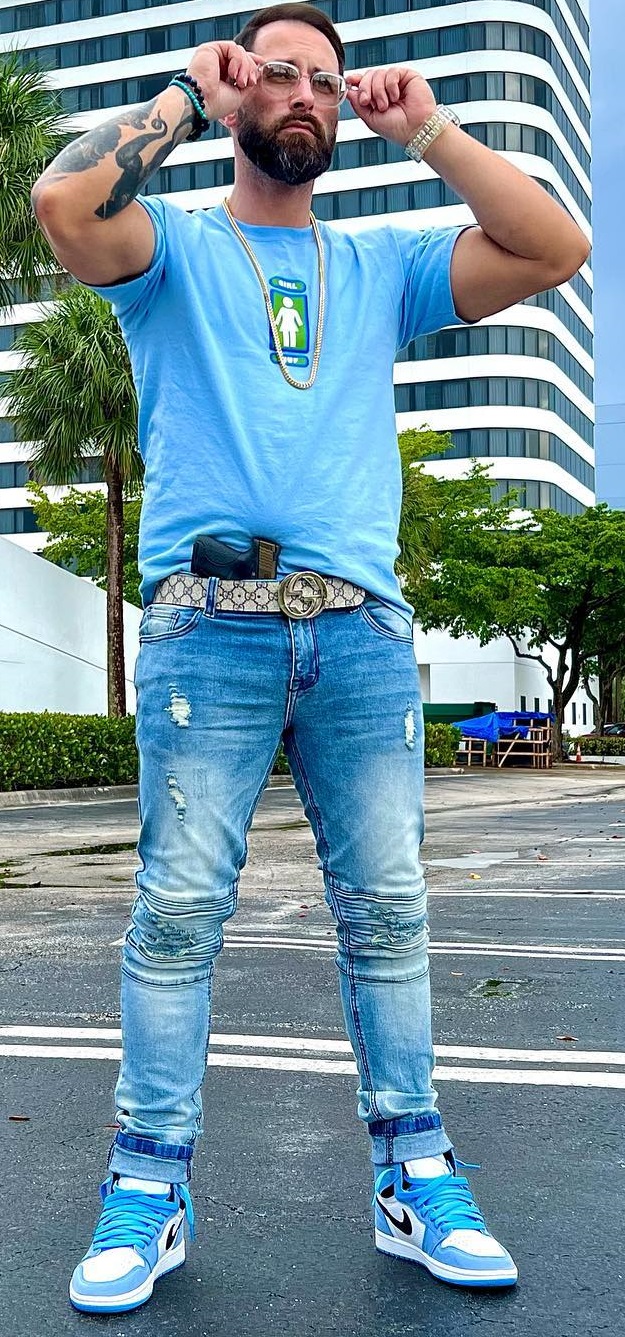 Gucci belt being a must-have product to buy with denims and blue tshirt, accessorized with glasses. neck-chain and a bracelet